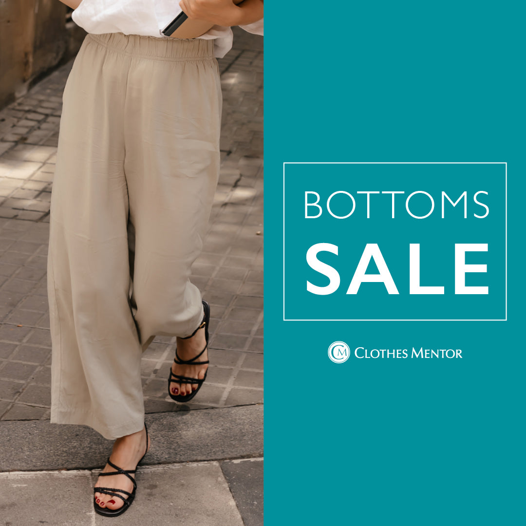 A promotional banner for a 'BOTTOMS SALE' by Clothes Mentor, featuring a model wearing loose, wide-leg beige linen pants and black strappy sandals on a paved street, next to a solid teal graphic panel with white text.
